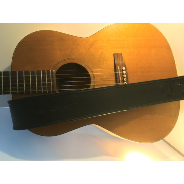 Hndlavet guitar rem i kernelder og med indslag af skind i kanten. 